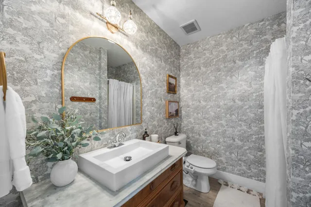 a bathroom with a sink toilet and mirror