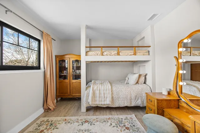 a bedroom with a bed and wooden floor