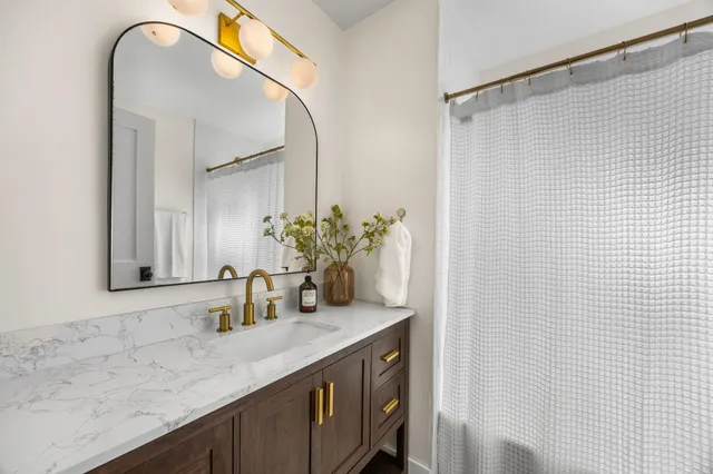 a bathroom with a granite countertop sink and a mirror