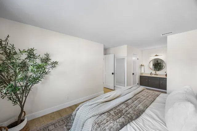 a bedroom with a bed and a potted plant