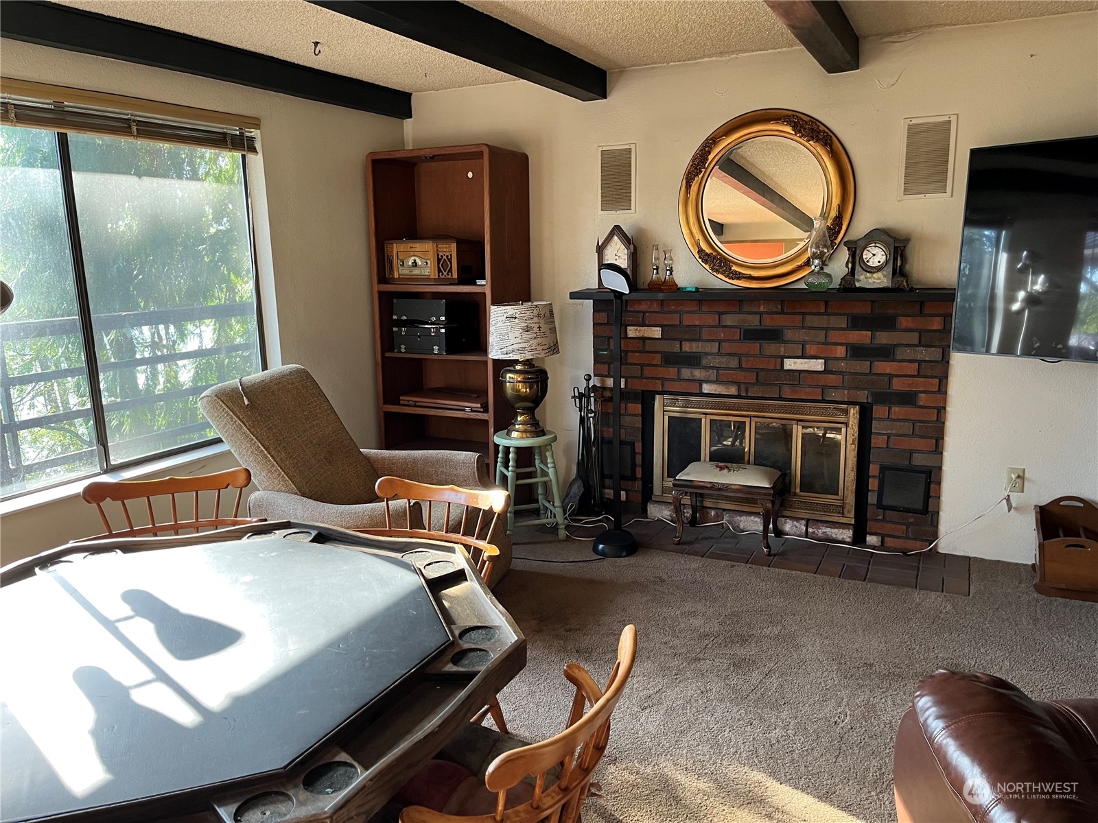 1481 Griffith Point Road Nordland, WA 98358 - Photo 8 of 39 a living room with furniture a fireplace a clock and a large window