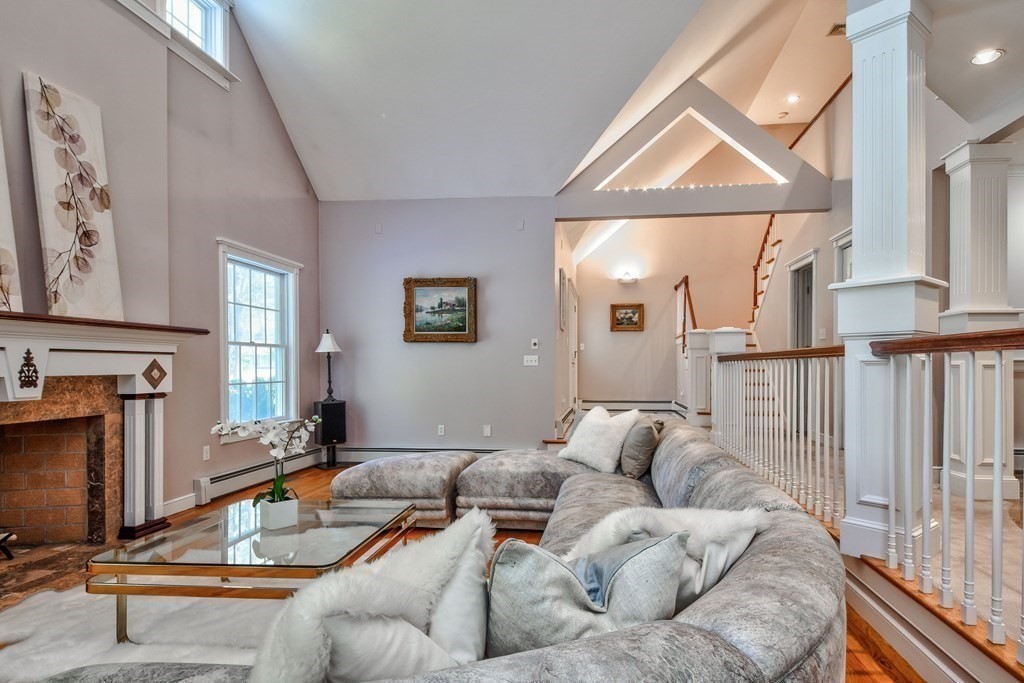 6 Barnbridge Circle Framingham, MA 01701 - Photo 7 of 41 a living room with furniture a fireplace and a floor to ceiling window