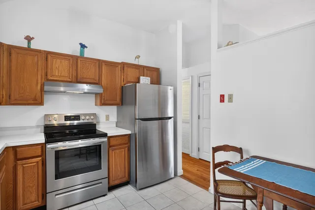 a kitchen with a refrigerator a stove and a cabinets