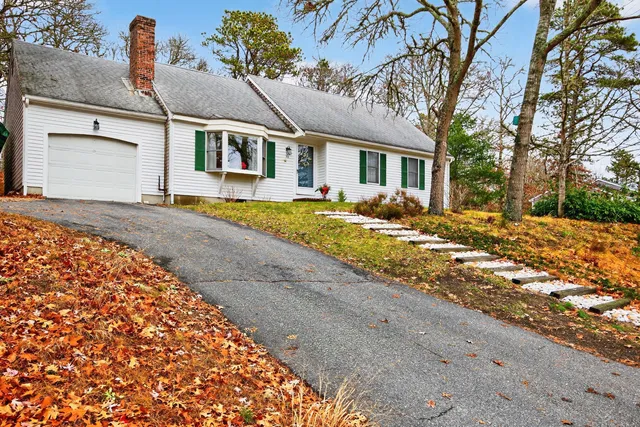 a view of a house with a yard and large tree