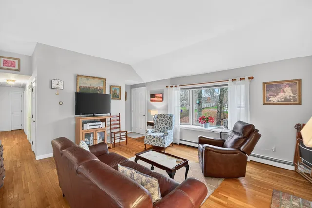 a living room with furniture a flat screen tv and a large window