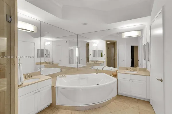 a bathroom with a tub sink and mirror