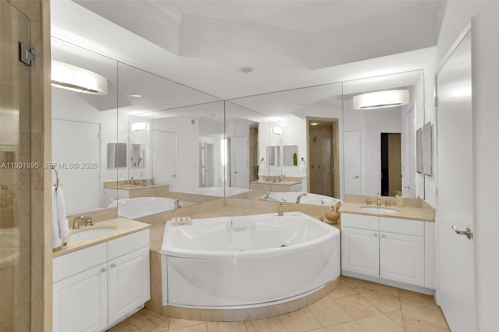 735 Crandon Boulevard, Unit 503 Key Biscayne, FL 33149 - Photo 10 of 38 a bathroom with a tub sink and mirror