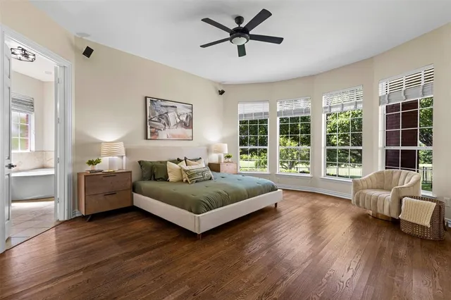 a spacious bedroom with a bed couch and a large window