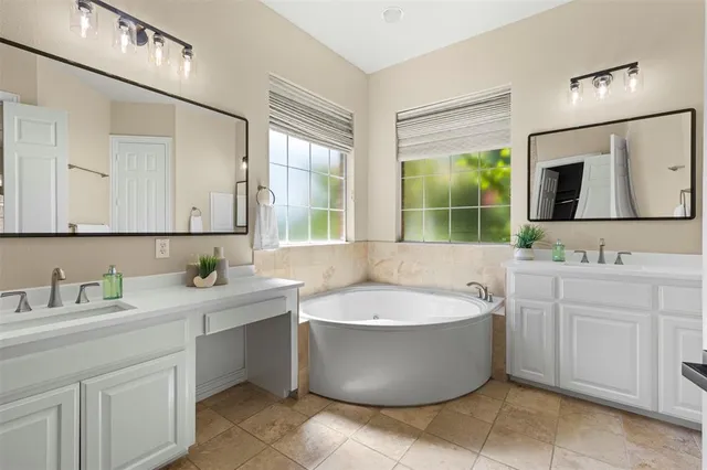 a bathroom with a tub a sink and mirror