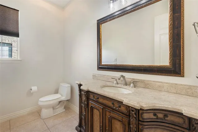 a bathroom with a granite countertop sink a toilet and a mirror