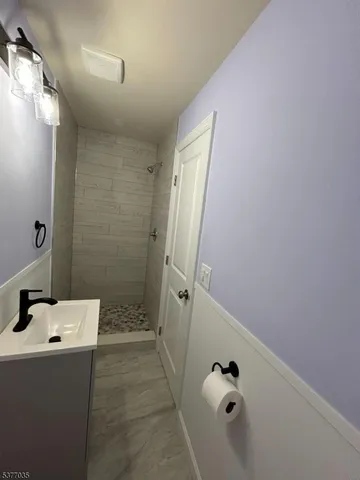 a bathroom with a tub shower and mirror
