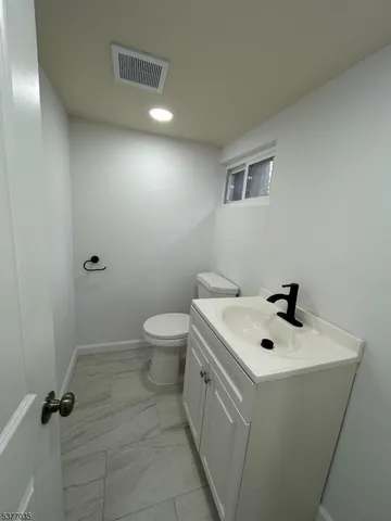 a bathroom with a sink a toilet and a mirror