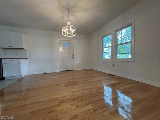 an empty room with wooden floor and window