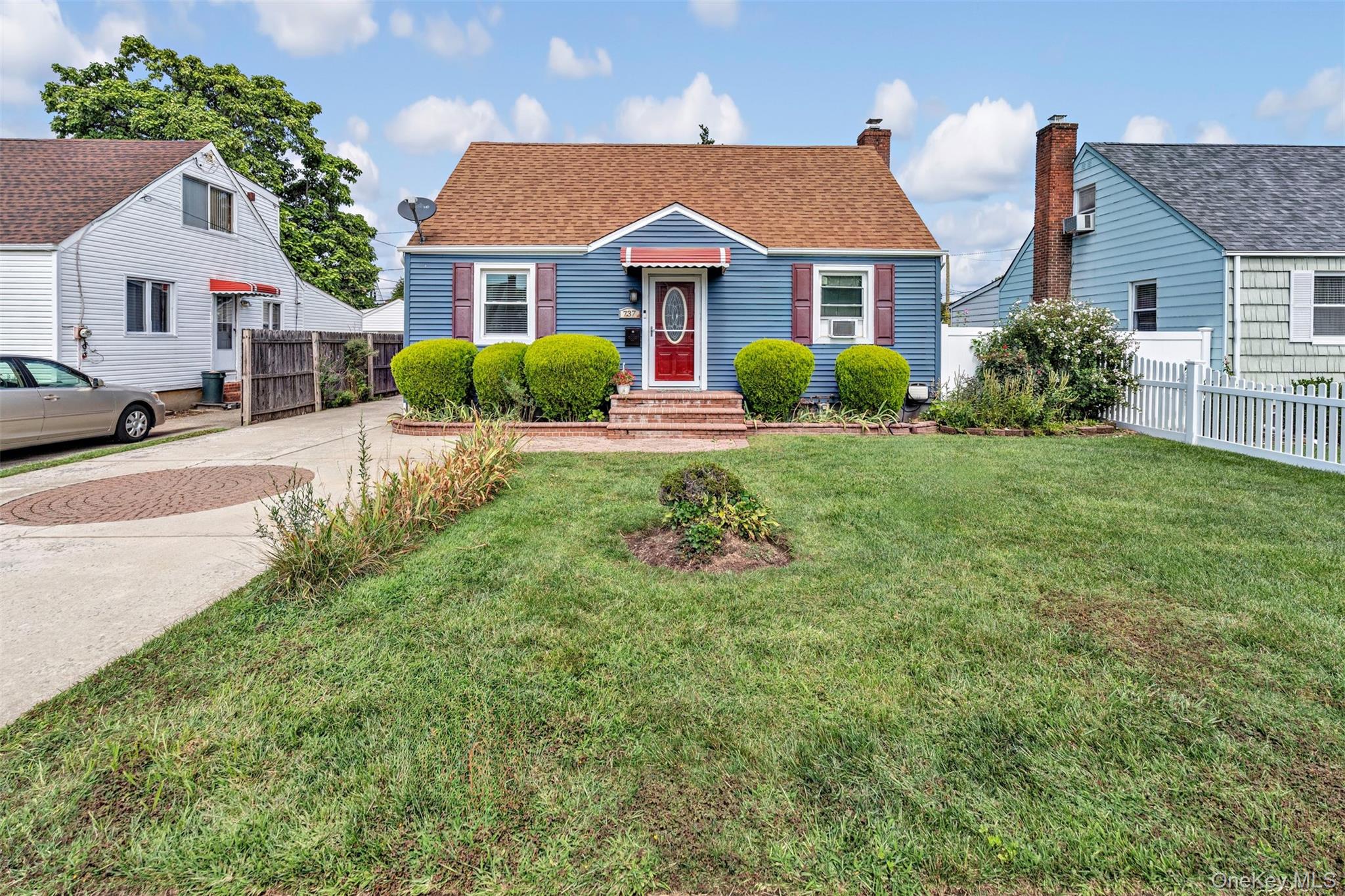 737 Lowell Road Uniondale, NY 11553 - Photo 1 of 1 front view of a house next to a yard
