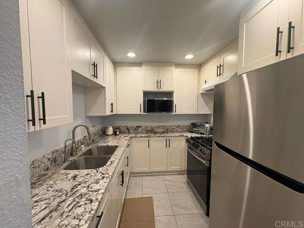 440 L Street, Unit J Chula Vista, CA 91911 - Photo 5 of 10 a kitchen with a refrigerator sink and stove