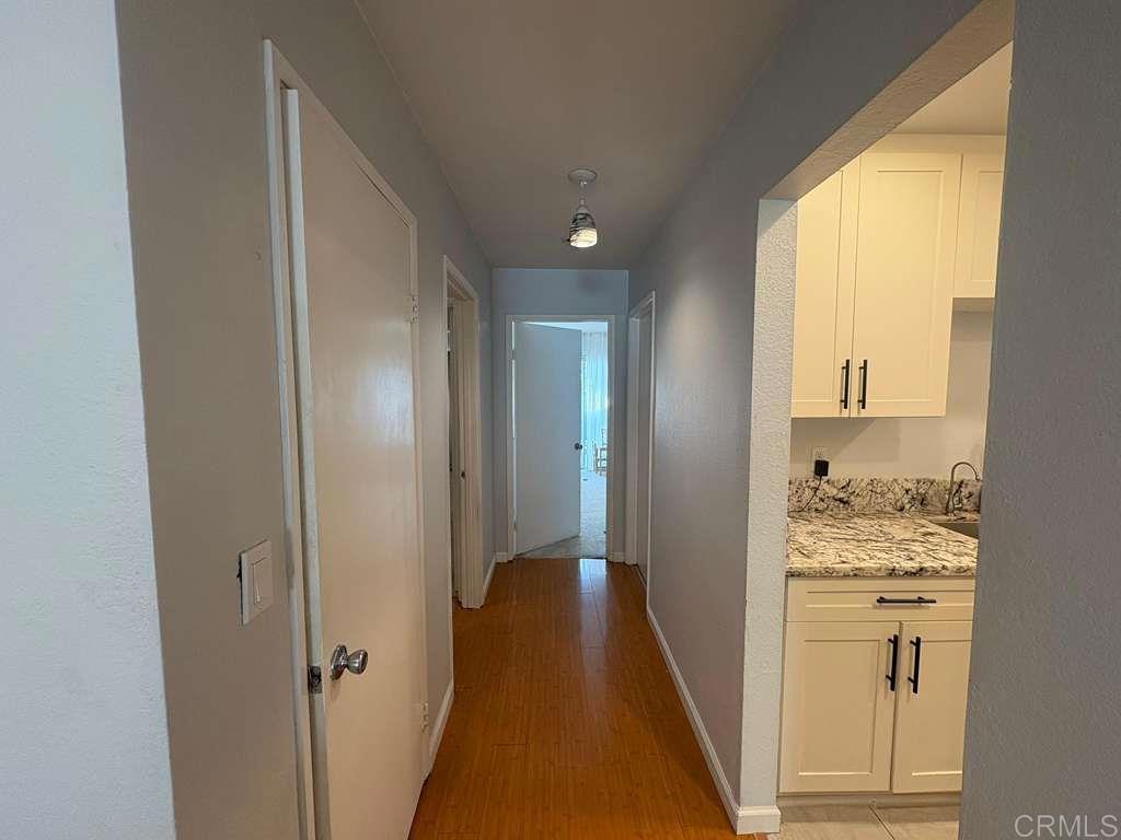440 L Street, Unit J Chula Vista, CA 91911 - Photo 9 of 10 a view of a hallway with wooden floor and a bathroom