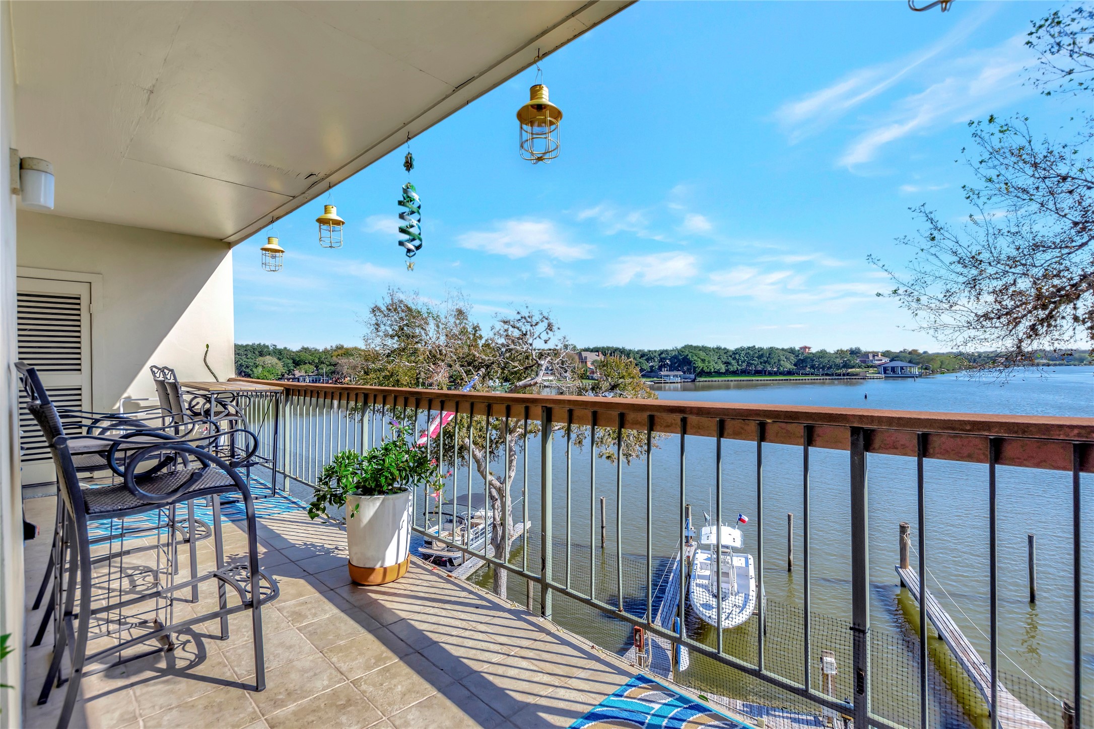18809 Egret Bay Boulevard, Unit 112 Webster, TX 77058 - Photo 4 of 48 a balcony with wooden floor outdoor seating and city view