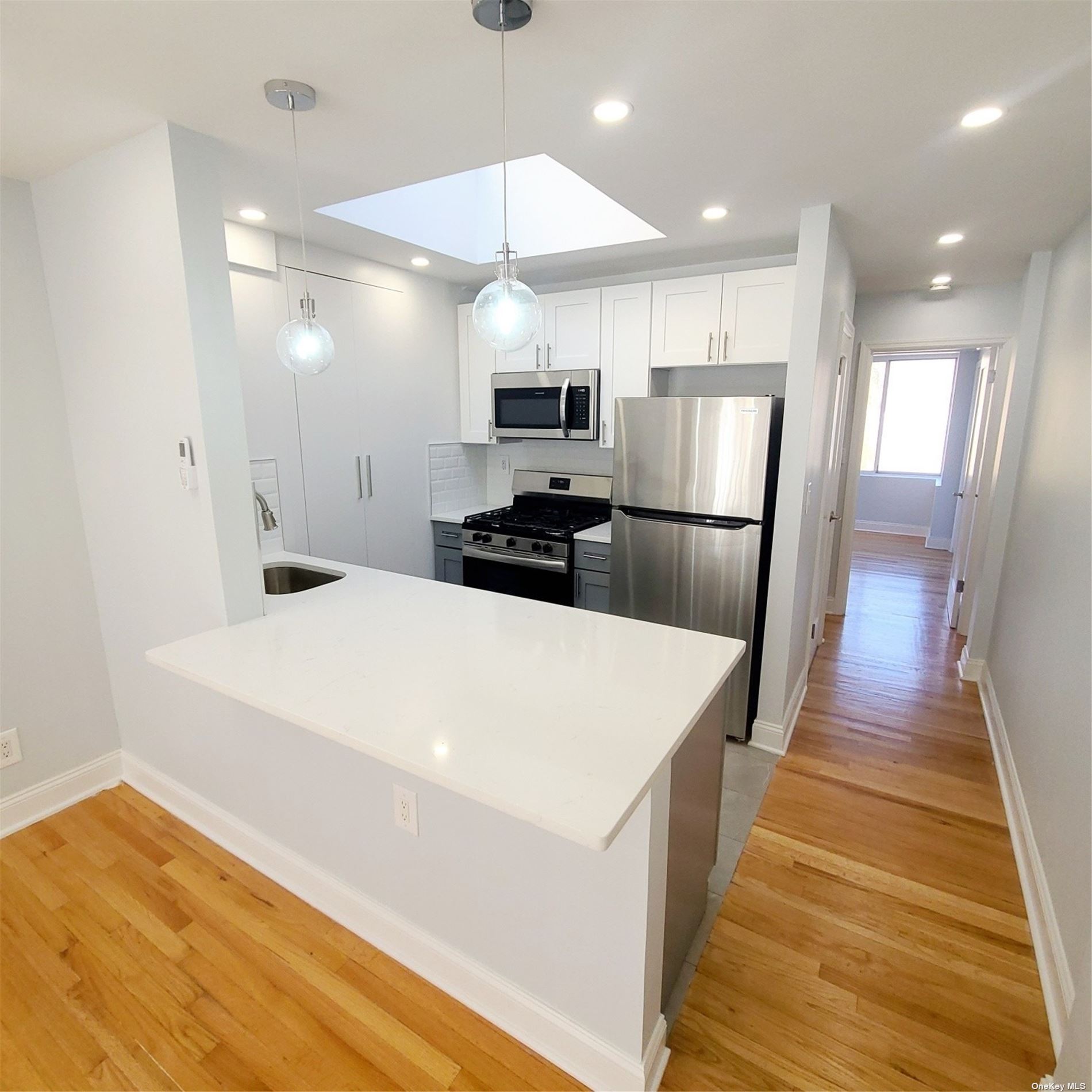 67-39 Clyde Street, Unit G Queens, NY 11375 - Photo 6 of 23 a kitchen with stainless steel appliances a refrigerator sink and microwave