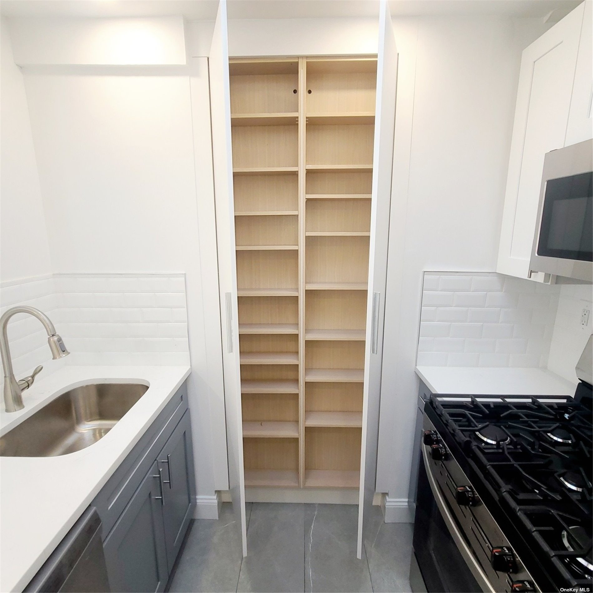 67-39 Clyde Street, Unit G Queens, NY 11375 - Photo 10 of 23 a kitchen with a sink and a stove top oven