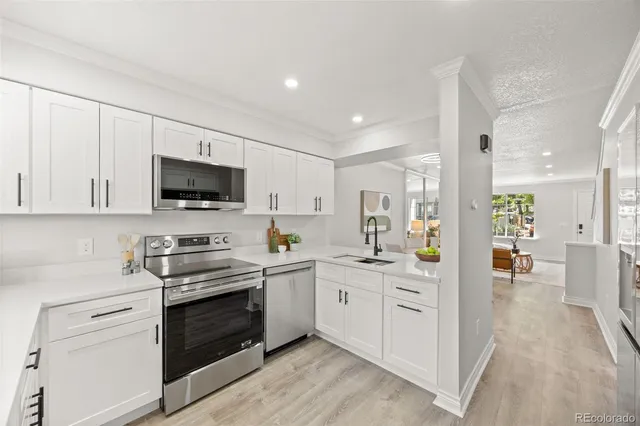 a kitchen with stainless steel appliances a stove sink and white cabinets