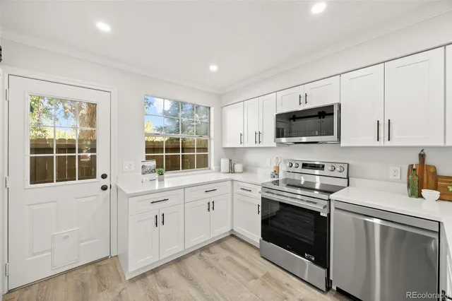 a kitchen with appliances a sink and cabinets