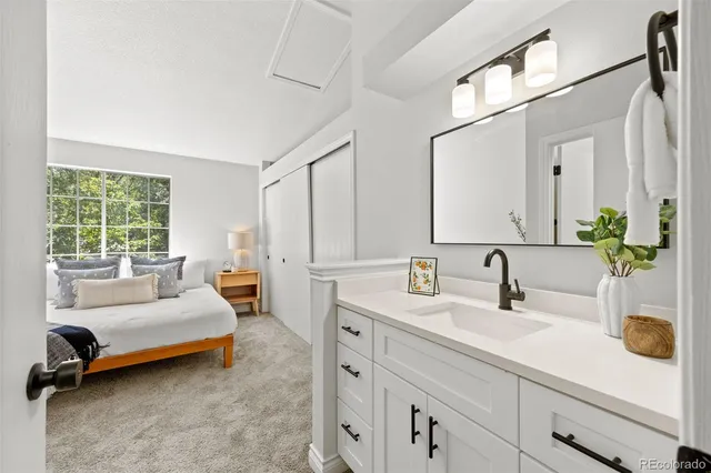 a spacious bedroom with a bed a table window and couch