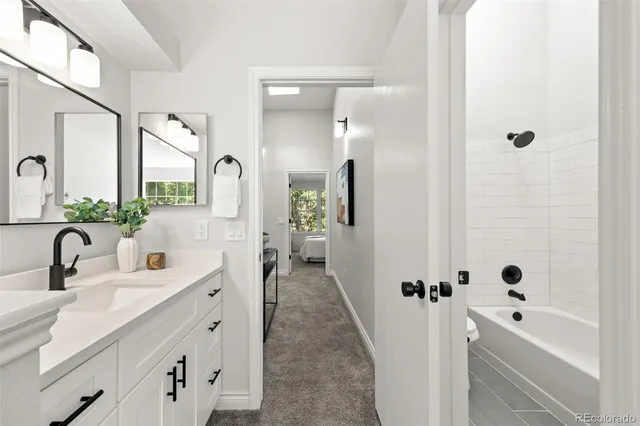 a bathroom with a double vanity sink a mirror a bathtub and shower