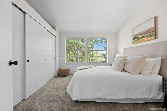 a large bed sitting in a bedroom next to a window