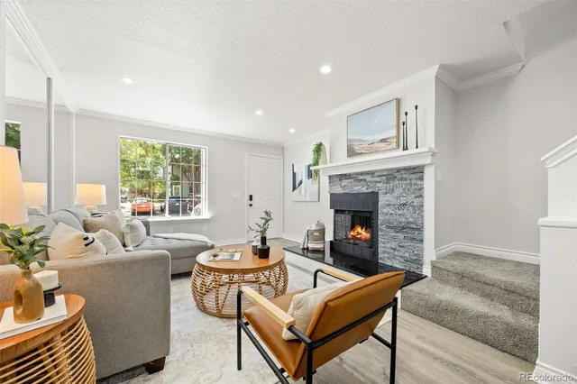 a living room with furniture a fireplace and a window