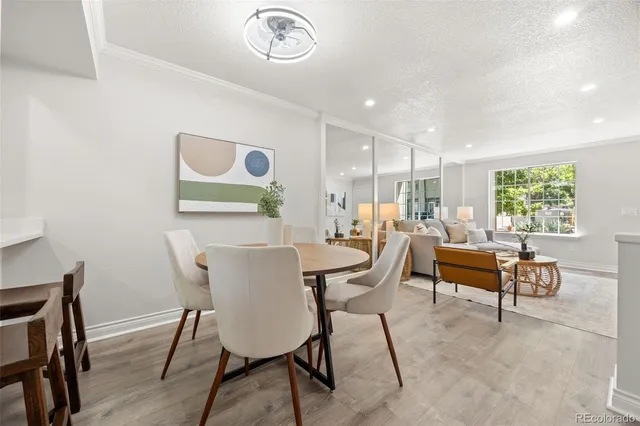 a view of a dining room with furniture a rug and wooden floor