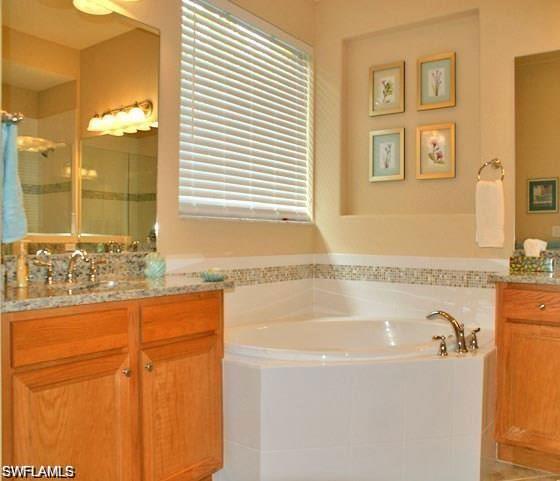 7414 Acorn Way Naples, FL 34119 - Photo 7 of 24 a bathroom with bathtub and window