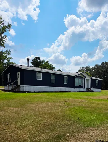 a view of a house with a yard and sitting area