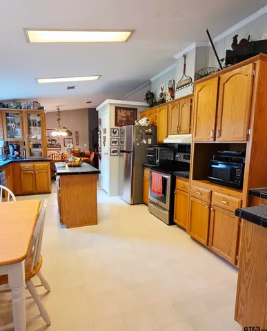 a kitchen with stainless steel appliances kitchen island granite countertop a sink and cabinets