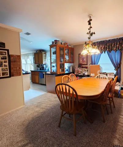 a dining room with furniture a chandelier and wooden floor