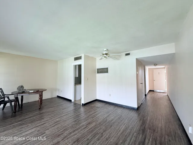 a view of a livingroom with wooden floor and furniture