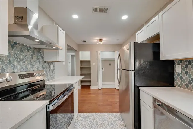a kitchen with stainless steel appliances a refrigerator a sink and a stove