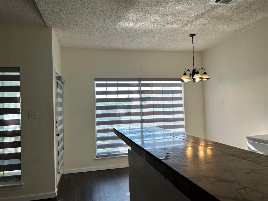 4107 Esters Road Irving, TX 75038 - Photo 6 of 21 Breakfast bar featuring a dark countertop