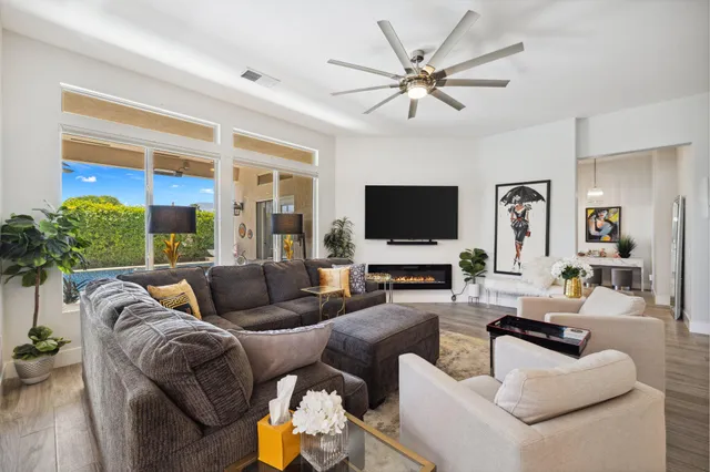 a living room with furniture a flat screen tv and a large window