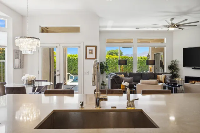 a living room with furniture a chandelier and a flat screen tv