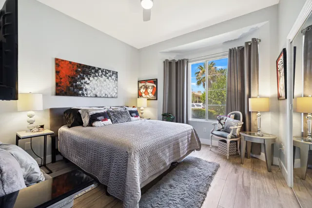 a bedroom with a bed and a potted plant on the dresser