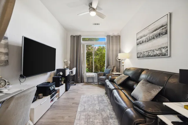 a living room with patio furniture and a floor to ceiling window