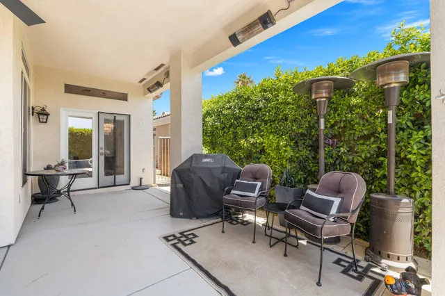 a living room with furniture fireplace and large windows