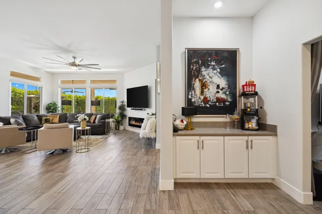 a living room with furniture a flat screen tv and a large window