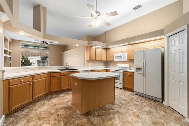 a kitchen with a sink refrigerator and cabinets