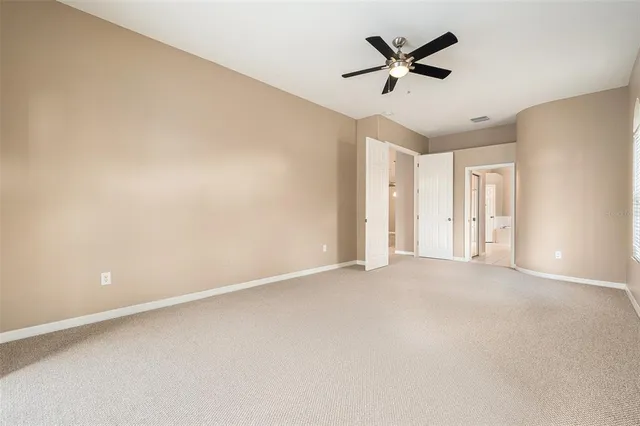 wooden floor in an empty room with a ceiling fan
