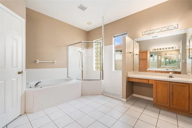 a large bathroom with a tub a sink and a large mirror