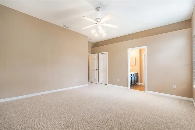 a view of an empty room with a ceiling fan
