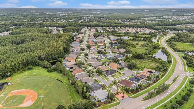 an aerial view of residential houses with outdoor space and trees