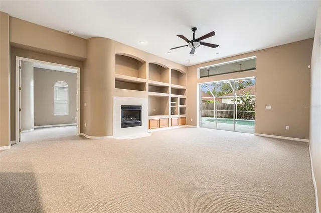 a view of an empty room with a fireplace and a window