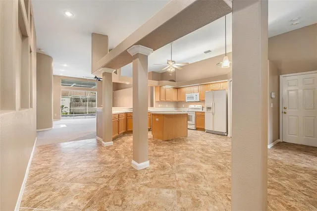 a view of a kitchen with refrigerator and wooden cabinets